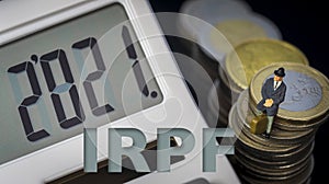 Income Tax Campaign 2021 Spain. Young Couple sitting on coin stack. Declaracion de la Renta. Macro photo