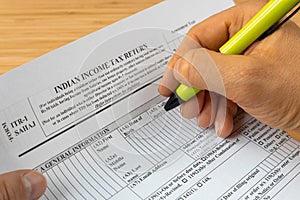 Income tax return in India, ITR1 form and hand with pen of the person completing the returns