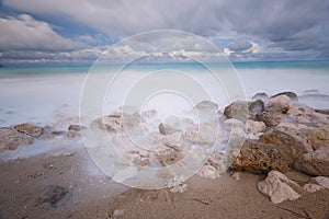 Incoming tides on a rocky beach under stormy skies