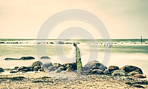 Incoming waves hitting vintage old wood at the coast. Long exposure