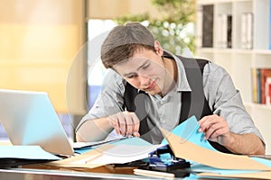 Incompetent messy businessman with disorganized desk photo