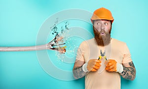 Incompetent worker electrician is unsure about his work. cyan background photo