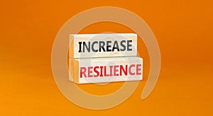 Increase resilience symbol. Concept word Increase resilience typed on wooden blocks. Beautiful orange table orange background.