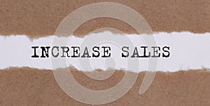 Increase sales written under torn paper on white background