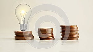 Increasing of electricity cost for residential and business users, expensive energy bill. Lots of coins and a light bulb