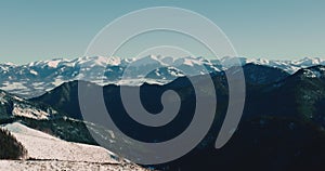 Incredible aerial background view of rich evergreen forest peaks and snow covered mountain tops on winter sunny morning.