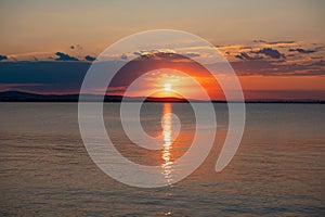 Incredible amazing, colorful summer sunsrise in Bulgaria Black coast. Orange sunset sky and reflection in the blue water