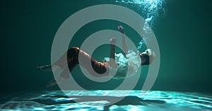 Incredible cinematic underwater view, young beautiful woman slowly sinks down helplessly slow motion. Depression concept