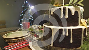 Incredible festive cozy Christmas tree atmosphere in dining room with ginger cake on New Year celebration dinner table