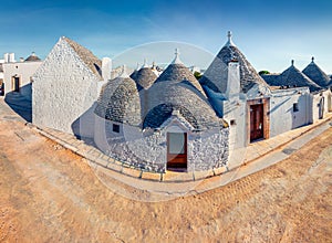 Incredible morning view of strret with trullo trulli -  traditional Apulian dry stone hut with a conical roof. Sunny spring city photo