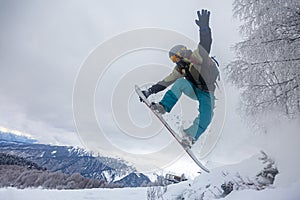 Incredible snowboard jump under the white snowy forest in a good winter day, freeride in a deep snow, ski season