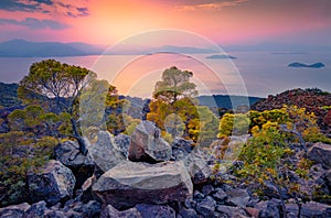 Incredible sunset on popular tourist destination - Methana Volcano with Saronic Islands on background.