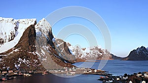 Incredible travel. Aerial view from flying drone of sea shore, snowy mountains, rorbuer in winter at sunset. Lofoten