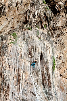 Incredible wall and young woman climbing.