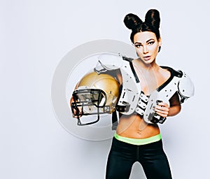 An incredibly beautiful, athletic brunette girl in a shoulderpads and an American football helmet demonstrating stunning