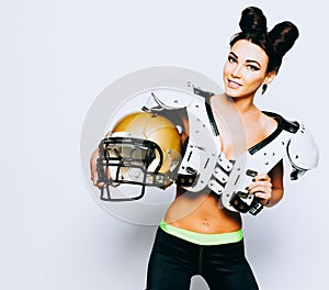 An incredibly beautiful, athletic brunette girl in a shoulderpads and an American football helmet demonstrating stunning