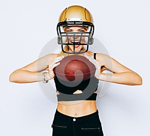 An incredibly beautiful blonde girl in a helmet posing in a black outfit and holding a ball. Sport. Match. American