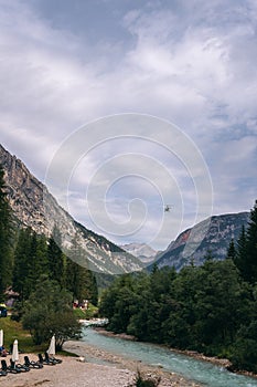 The incredibly beautiful river of turquoise color, with pine forest, summer day. Vertical photo. Copy space. Dolomites mountains,