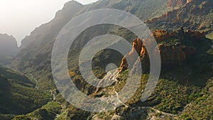 Incredibly beautiful sharp cliffs in the light of the setting sun. Ridges of rocks rise above the green vegetation