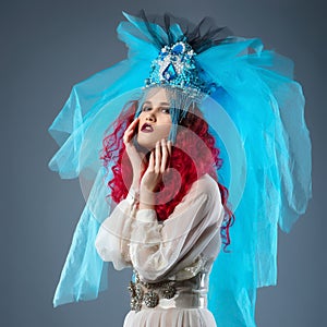 Incredibly fashion girl with red hair in crown and veil