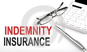 INDEMNITY INSURANCE Concept. Calculator,pen and glasses on white background