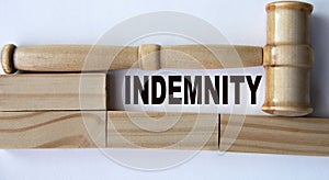 INDEMNITY - word on the background of wooden blocks and a judge\'s gavel