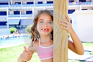 Indented kid girl ok gesture in pool garden