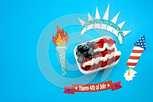 Independence day, happy fourth of july and dessert concept with the american flag made of raspberries and blueberries surrounded