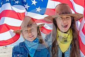 Independence Day. Happy kids, cute two girls with American flag. USA celebrate 4th of July