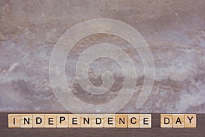 Independence day text with alphabet wooden block cube on table dark plank wooden background with copy space