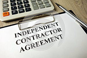 Independent Contractor Agreement with calculator and pen