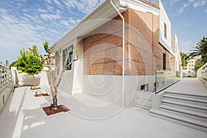 Independent residential single-family house on land with white marble floors and tree grates, marble stairs and glass railing