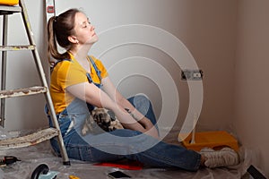 Independent single female sitting on floor and rest with pet dog in her new house during renovation, construction tools