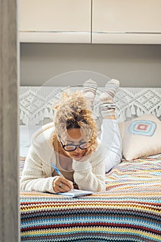 Independent woman planning next destination travel road trip laying on the bed in her camper van bedroom. Concept of alternative