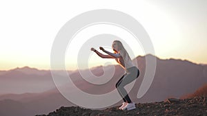 Independent young woman jump on top of mountain stands and enjoys the view after climbing celebrating achievement girl