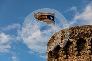 Independentist flag waving on top of medieval tower cloud