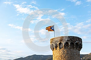 Independentist flag waving on top of medieval tower cloud