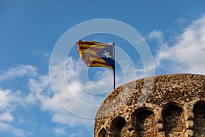 Independentist flag waving on top of medieval tower cloud