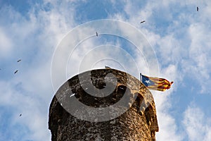 Independentist flag waving on top of medieval tower cloud