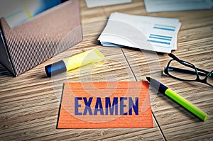 Index cards with legal issues with glasses, pen and bamboo with the german word examen in english exam