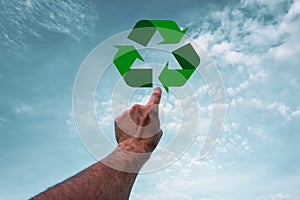 index finger pointing to the recycling symbol