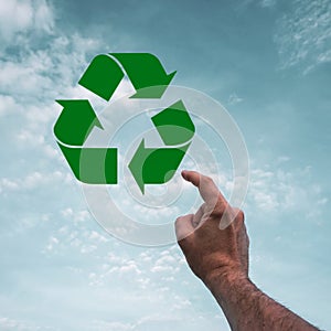 index finger pointing to the recycling symbol