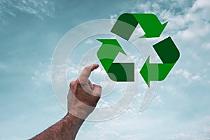 index finger pointing to the recycling symbol