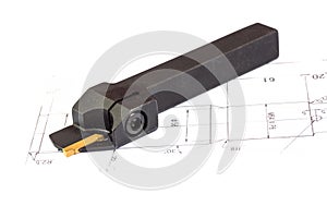 Indexable lathe tool with replaceable tip on blueprint background