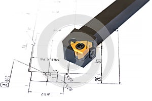 Indexable lathe tool with replaceable tip on blueprint background