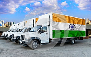 India flag on the back of Five new white trucks against the backdrop of the river and the city. Truck, transport, freight