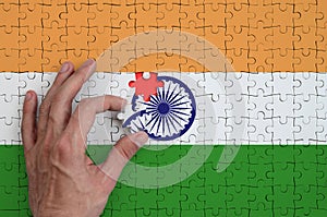 India flag is depicted on a puzzle, which the man`s hand completes to fold