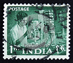 India postage stamp shows man working in a factory, series, circa 1954