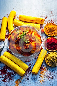 Indian appetizer dish i.e.Teekha Laal Batata or Spicy potato with all its ingredients and spices on a sliver wooden surface.This d