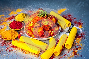 Indian appetizer dish i.e.Teekha Laal Batata or Spicy potato with all its ingredients and spices on a sliver wooden surface.This d